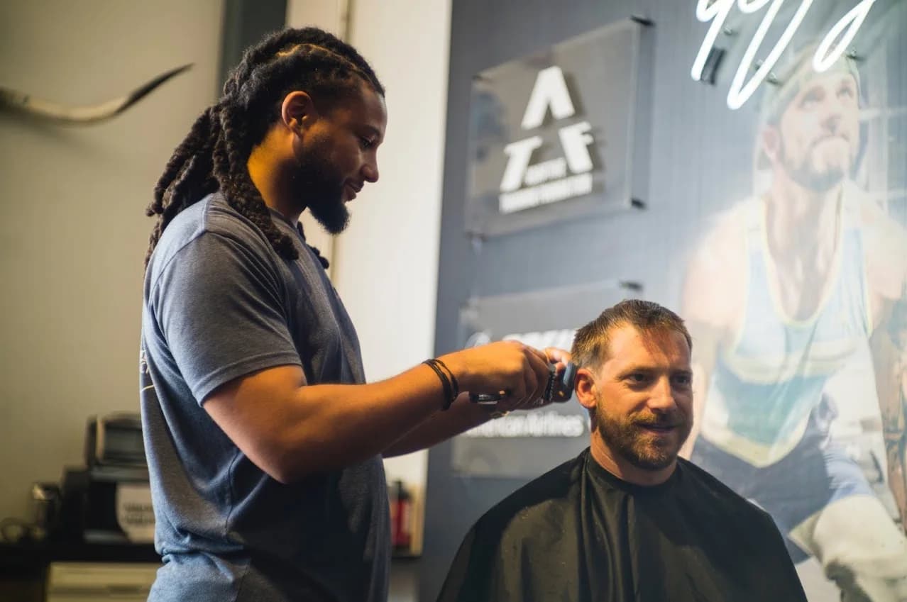 Andre carefully shaping a client's hair with clippers in the barber chair